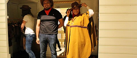 Das Bild würde Studierende zeigen, die sich an einer Mitmach-Station in der Kinderausstellung zum Thema "Cowboy und Indianer" verkleidet haben.