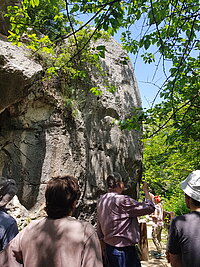 Der Professor zeigt einer Gruppe von Studierenden ein am Flussufer in den Fels gehauenes Relief des Hethiterkönigs Muwatalli II. 